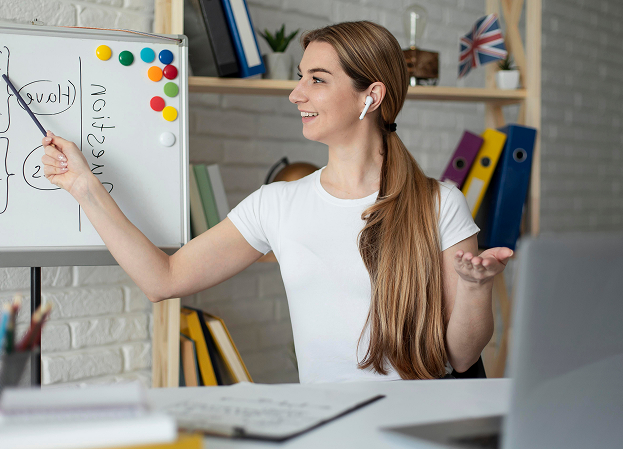 Online instructor pointing at a whiteboard during a lesson.